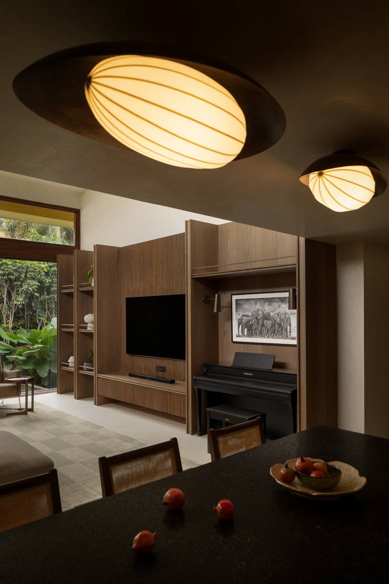 The same view with the oval ceiling lights switched on, glowing warm over the dining table