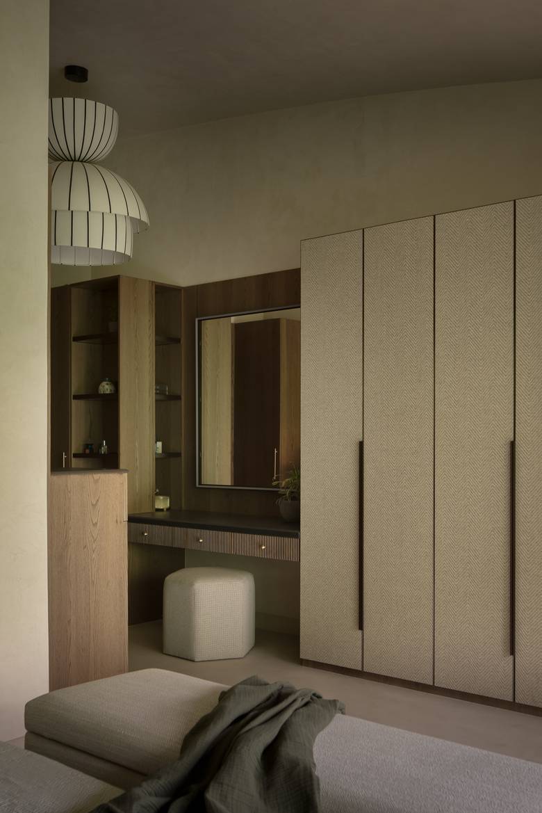 Dressing corner with a floor-to-ceiling textured wardrobe, a dressing table with a mirror and a striped layered pendant